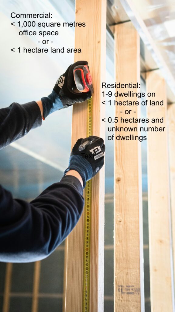 construction worker measuring along wall studs